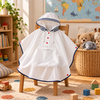 Poncho Petit Explorateur posé sur une petite chaise dans une chambre d'enfant