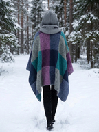 Poncho Mosaïque Hiver – coloris Bleu-vert et violet, porté dans une forêt enneigée, capuche en maille relevée, vu de dos