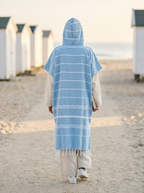 Poncho Fouta Bord de Mer – coloris Bleu ciel, porté capuche relevée sur la plage, vu de dos