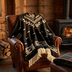Poncho Homme Rancho posé sur un fauteuil en cuir près d'un poêle à bois, dans un chalet